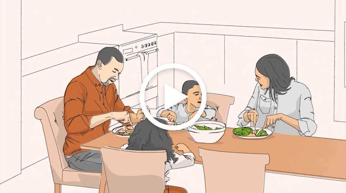 A family with two children sitting at a table in the kitchen eating.
